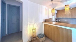 Une cuisine moderne avec des meubles en bois, un plan de travail et un luminaire suspendu.
