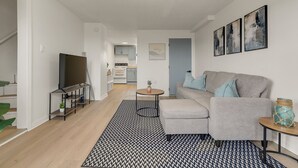 Una sala de estar moderna con un sofá, una mesa de centro y un mueble para la televisión.