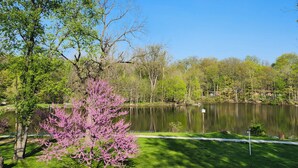 Un parque con un lago, árboles y una zona cubierta de césped.