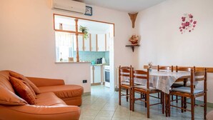 A living room with a sofa, dining table, chairs, and a kitchen in the background. - Apartment 2425/200961 (Istria - Rovinj), 1300m from the beach (Rovinj)