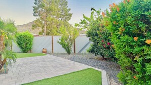 A paved pathway leading to a grassy area with a fence and trees in the background. - 3-bedroom gem in Central Phoenix (Phoenix)