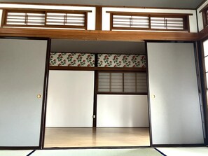 A traditional Japanese room with sliding doors, tatami flooring, and shoji screens.