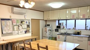 Eine Küche mit Holmöbeln, einem Kühlschrank, einer Mikrowelle und einem Spülbecken.