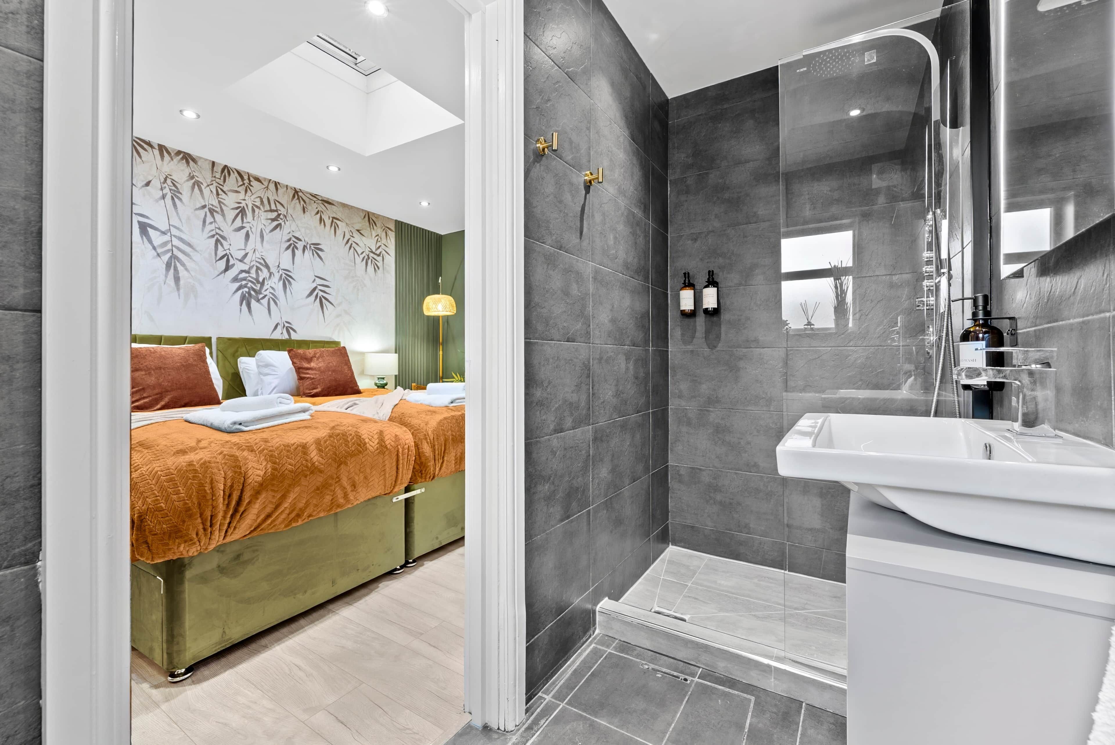 Ein modernes Hotelzimmer mit Bett, Dusche und Badezimmer mit Waschbecken.