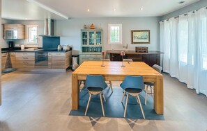 A modern kitchen with a dining area, a large window, and a painting on the wall. - Gorgeous home in Speracedes with WiFi (Speracedes)