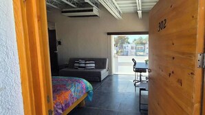 Une chambre avec un lit, un canapé, une table et une porte portant le numéro 302.