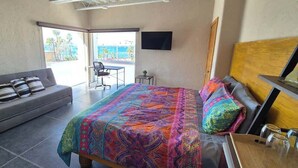Une chambre à coucher comprenant un lit, un canapé, un bureau, une chaise et un téléviseur.