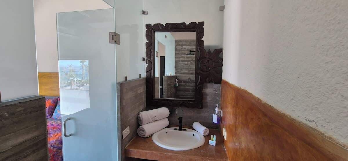 A bathroom with a wooden vanity, a sink, and a mirror.