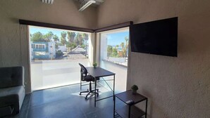 Une pièce comprenant un bureau, une chaise et une petite table sur laquelle est posée une plante.