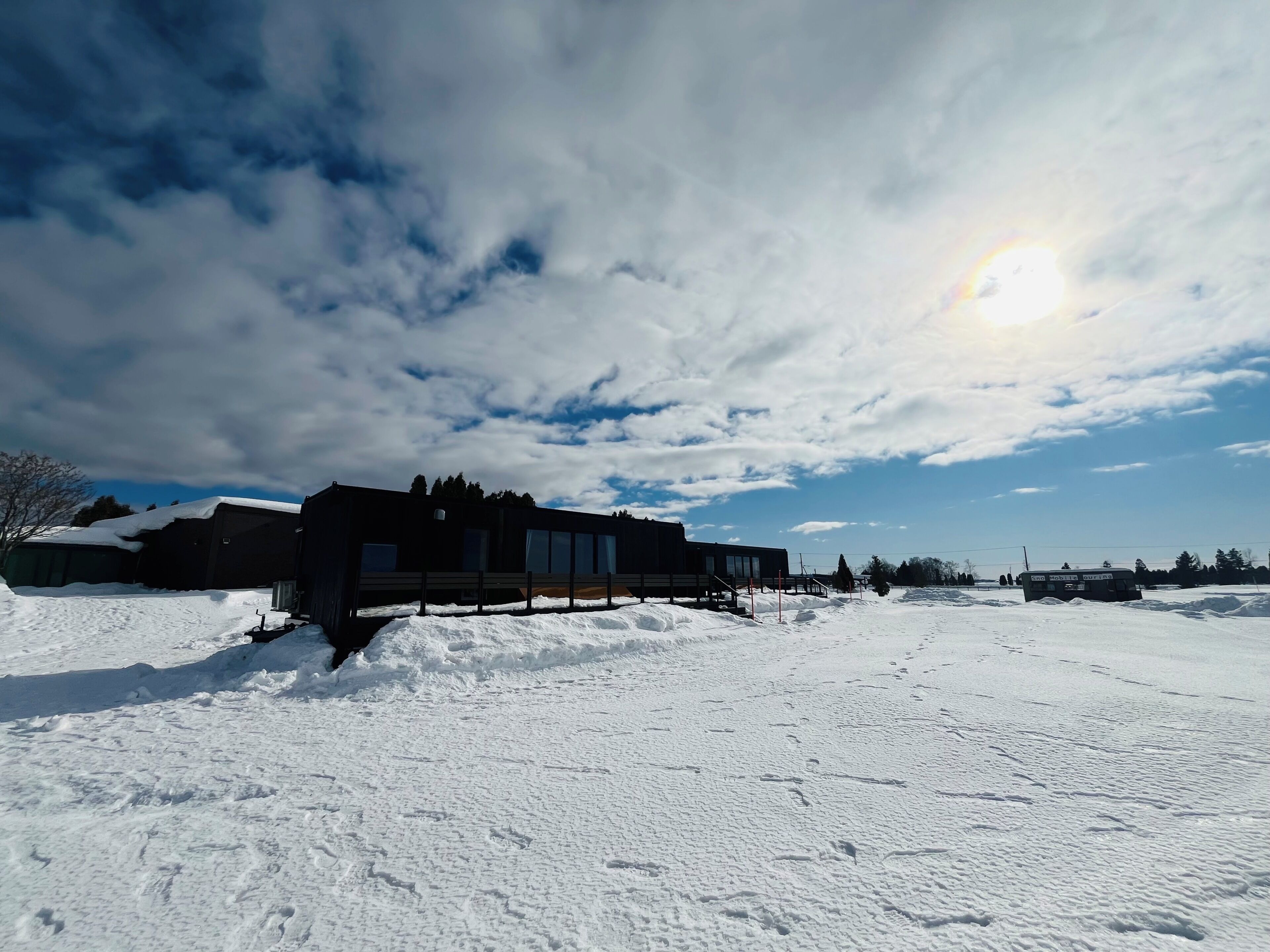A snow-covered landscape with a building and a bus.