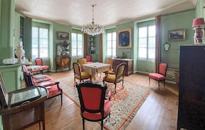 Ein Esszimmer mit einer Kronleuchter, Holzzmöbeln und einem gemusterten Teppich.