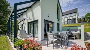 A modern house with a patio, outdoor seating, and a grill area. - Modern vineyard home with private jacuzzi (Margečan)