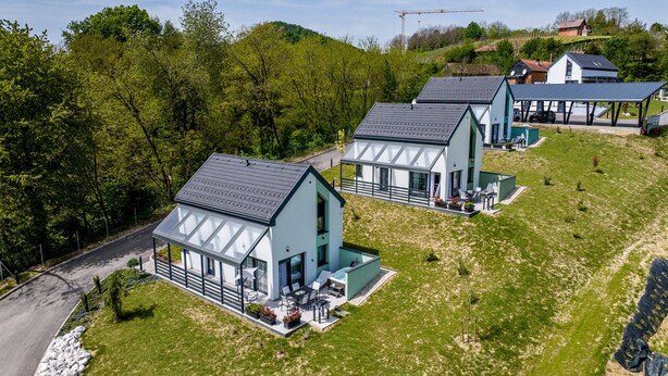A modern residential area with detached houses featuring large windows, outdoor seating, and a well-maintained lawn. - Modern vineyard home with private jacuzzi (Margečan)