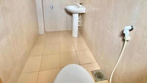 Un baño pequeño con inodoro, lavamanos y ducha.
