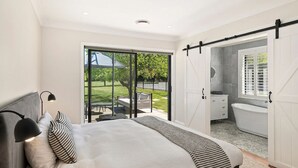 Une chambre à coucher avec un lit, un bureau et une vue sur l’extérieur.