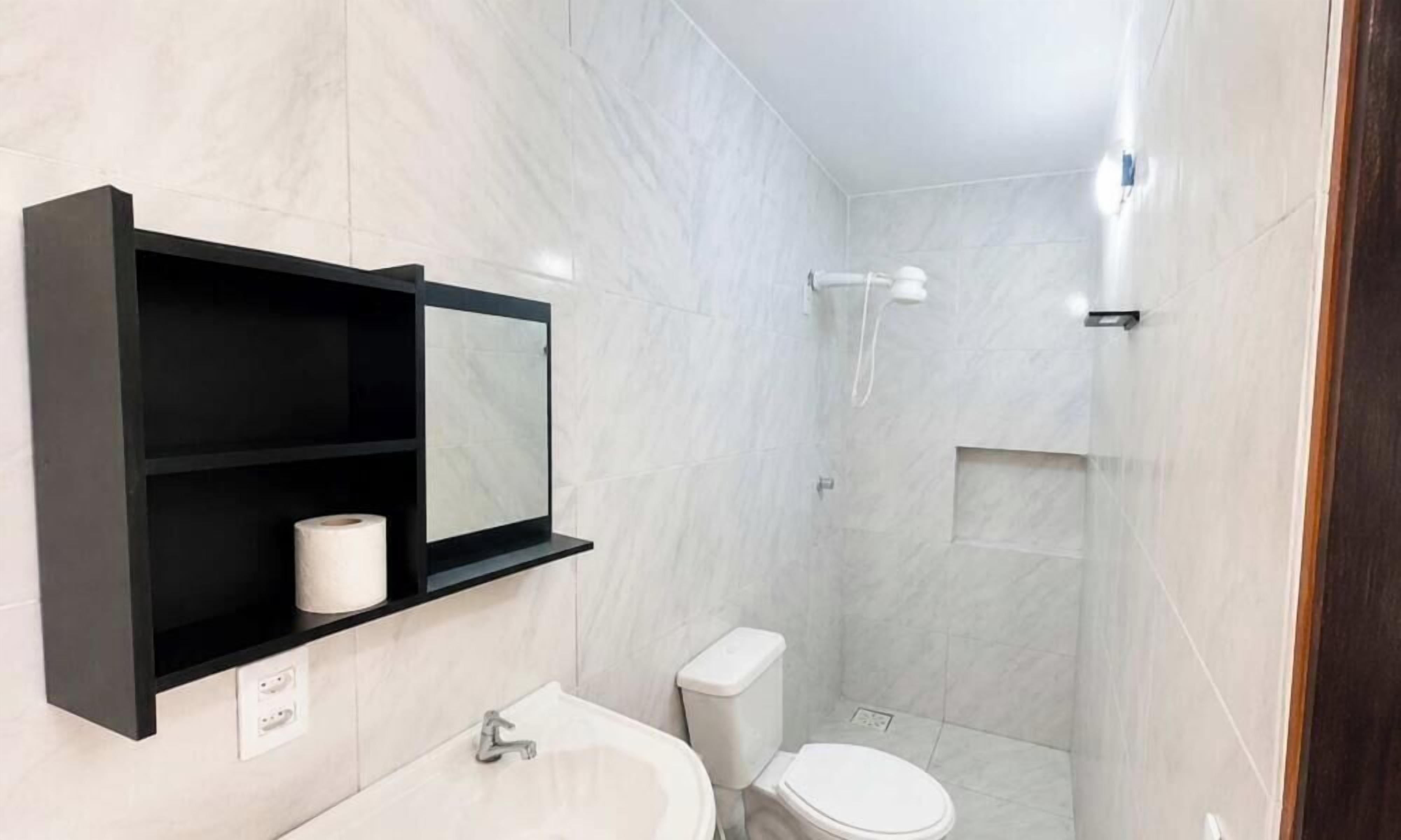 Un baño moderno con inodoro, lavabo y ducha.