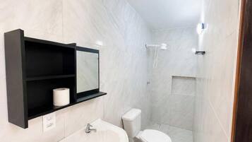 Un baño moderno con inodoro, lavabo y ducha.