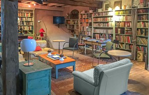 Ein gemütliches Zimmer mit einer Bücherwand, einem Fernseher und einem Essbereich.