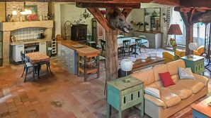 Een rustieke keuken met een eethoek, een bank en een tafel met stoelen.
