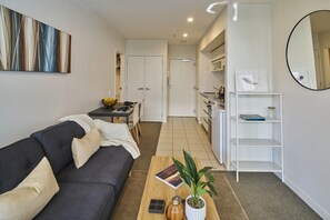 Uma sala de estar moderna com sofá, mesa de centro e área de jantar com mesa e cadeiras.