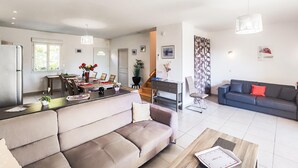 A modern living space with a sofa, dining table, and kitchen area. - Gorgeous home in Mirepeisset with outdoor swimming pool (Mirepeisset)
