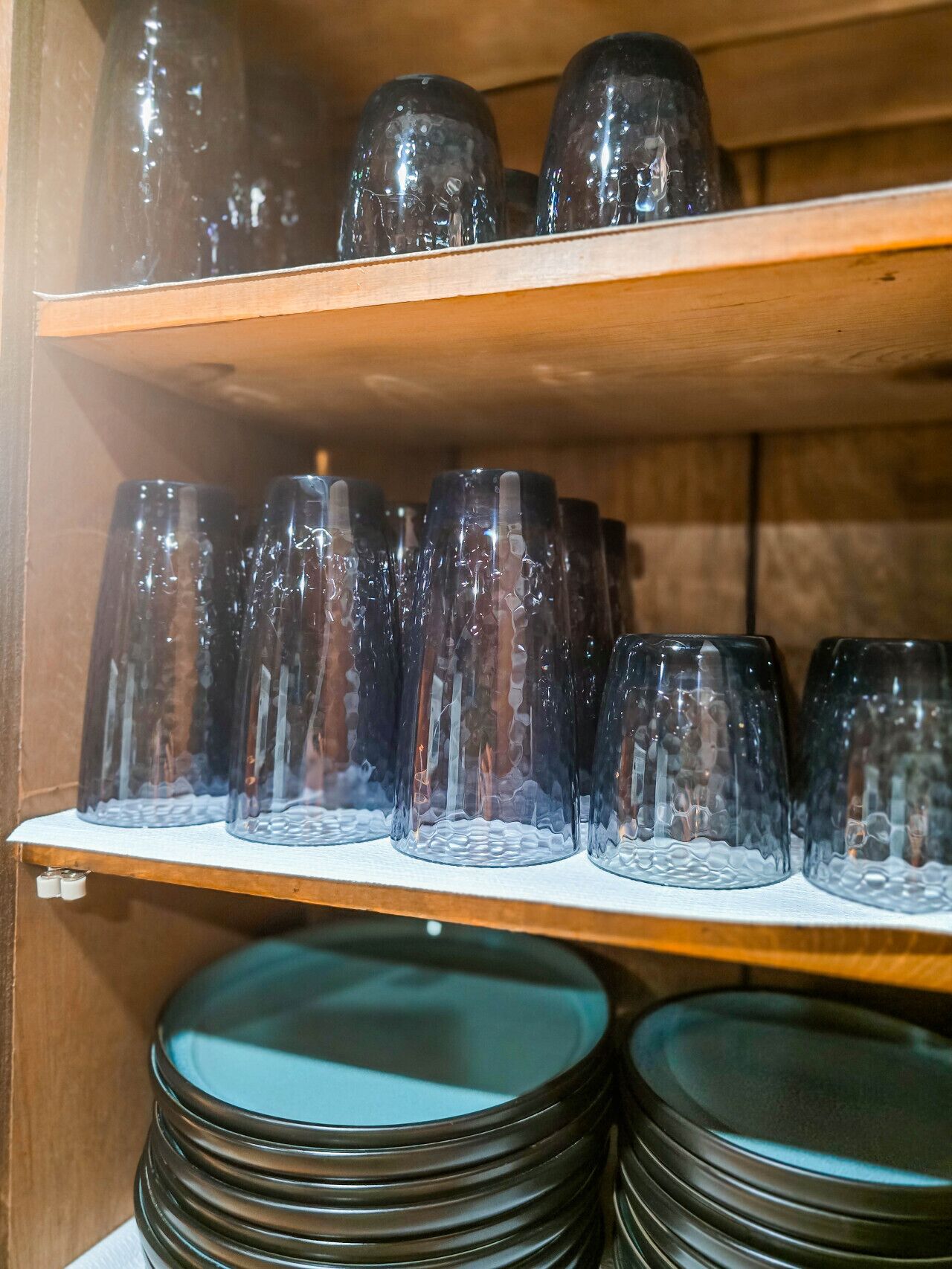 Shelves with stacked glassware and plates.