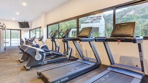 A gym with multiple treadmills, a stationary bike, and a rowing machine. - Oasis 408: Oasis Riverfront Luxury 2BR Infinity Pool & Views (Puerto Vallarta)