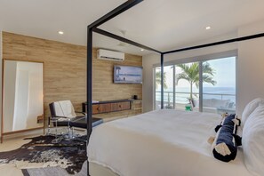 A modern bedroom with a large bed, a desk, a chair, a television, and a view of the ocean. - Gorgeous Ocean Views+Private Plunge Pool+Balcony (Puerto Vallarta)