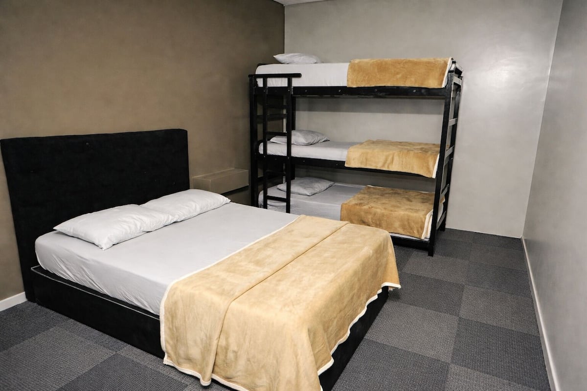 A bunk bed room with a single bed and a lower bunk.