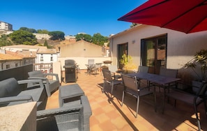 An outdoor patio with seating, a grill, and a red umbrella. - 4 bedroom stunning home in Béziers (Béziers)
