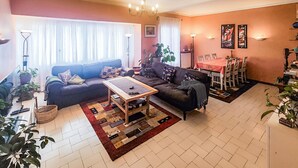 A living room with a sofa, coffee table, dining table, and chairs. There are potted plants and a chandelier. - 4 bedroom stunning home in Béziers (Béziers)