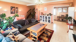 A living room with a sofa, coffee table, and a staircase leading to a kitchen area. - 4 bedroom stunning home in Béziers (Béziers)