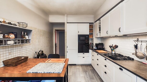 A narrow kitchen with white cabinets, a wooden table, and a tiled backsplash. - 4 bedroom stunning home in Béziers (Béziers)
