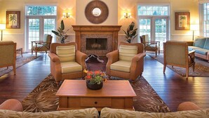 A spacious living room with a fireplace, multiple seating options, and large windows. - Worldmark Orlando Kingstown Reef Studio Deluxe (Orlando)