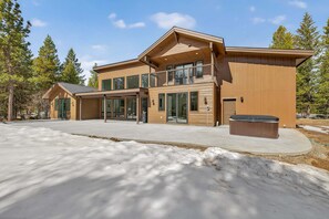 Un bâtiment moderne à deux étages, doté de grandes fenêtres, d’un patio couvert et d’un jacuzzi.