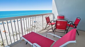 A balcony with a view of the beach, red and white furniture, and a table. - Pet Friendly! Beach Front- East Corner Unit- 2 Pools- Caribbean 501 (Gulf Shores)