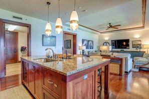 A spacious kitchen with granite countertops, a large island, and pendant lighting. - Kapalua Bay Resort | Ocean View 6 BR | Car Incl. w/ 6+ Nights | MON ML-3807 by KBM (Lahaina)
