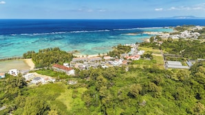 Vue aérienne d’une ville côtière, avec ses bâtiments, sa plage et ses eaux bleues et limpides.