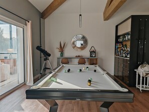Ein Billardtisch mit Kugeln, ein Teleskop, ein Spiegel und ein Globus.