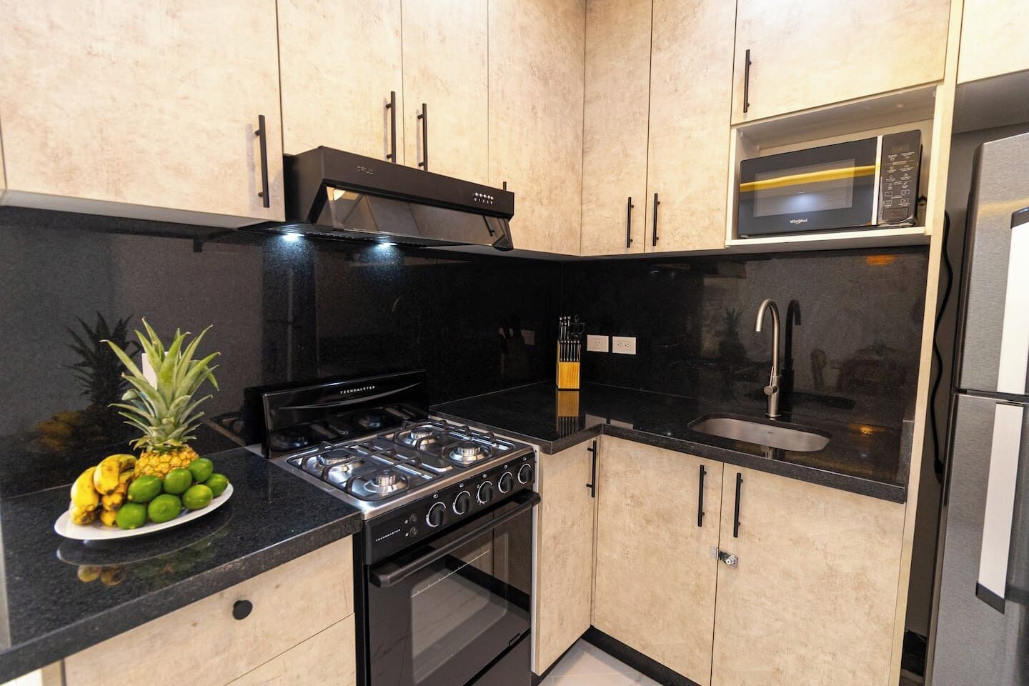 A kitchen with a gas stove, oven, microwave, and a sink.