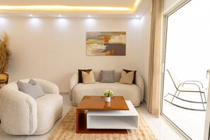 A modern living room with a sofa, a coffee table, and a chair. - Chic 1BR Maravilla Bayahibe · Pool · Beach · AC · Kitchen (San Rafael del Yuma)