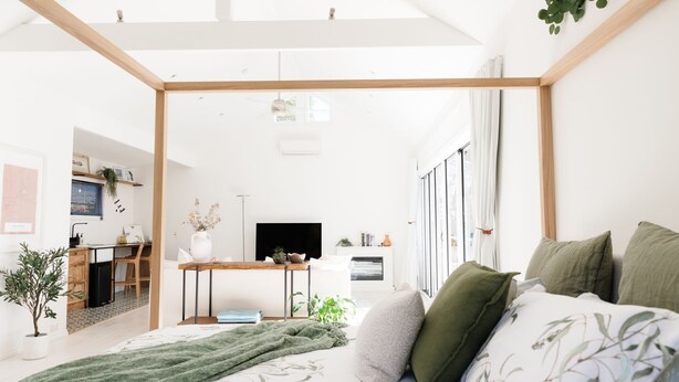 Een moderne slaapkamer met een bed, bureau en televisie.