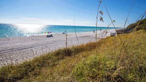 Ein Strand mit blauem Himmel, sandigem Ufer und einigen Booten.