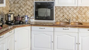 A kitchen with white cabinetry, a stove, an oven, and a sink. - Nice home in Regusse with private swimming pool, can be inside or outside (Regusse)
