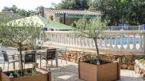 An outdoor seating area with tables and chairs, a stone wall, and a pool with a white balustrade. - Nice home in Regusse with private swimming pool, can be inside or outside (Regusse)