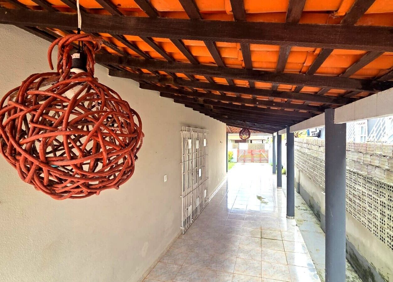 Un pasillo con una lámpara colgante de tejido, puertas metálicas y suelo de baldosas.