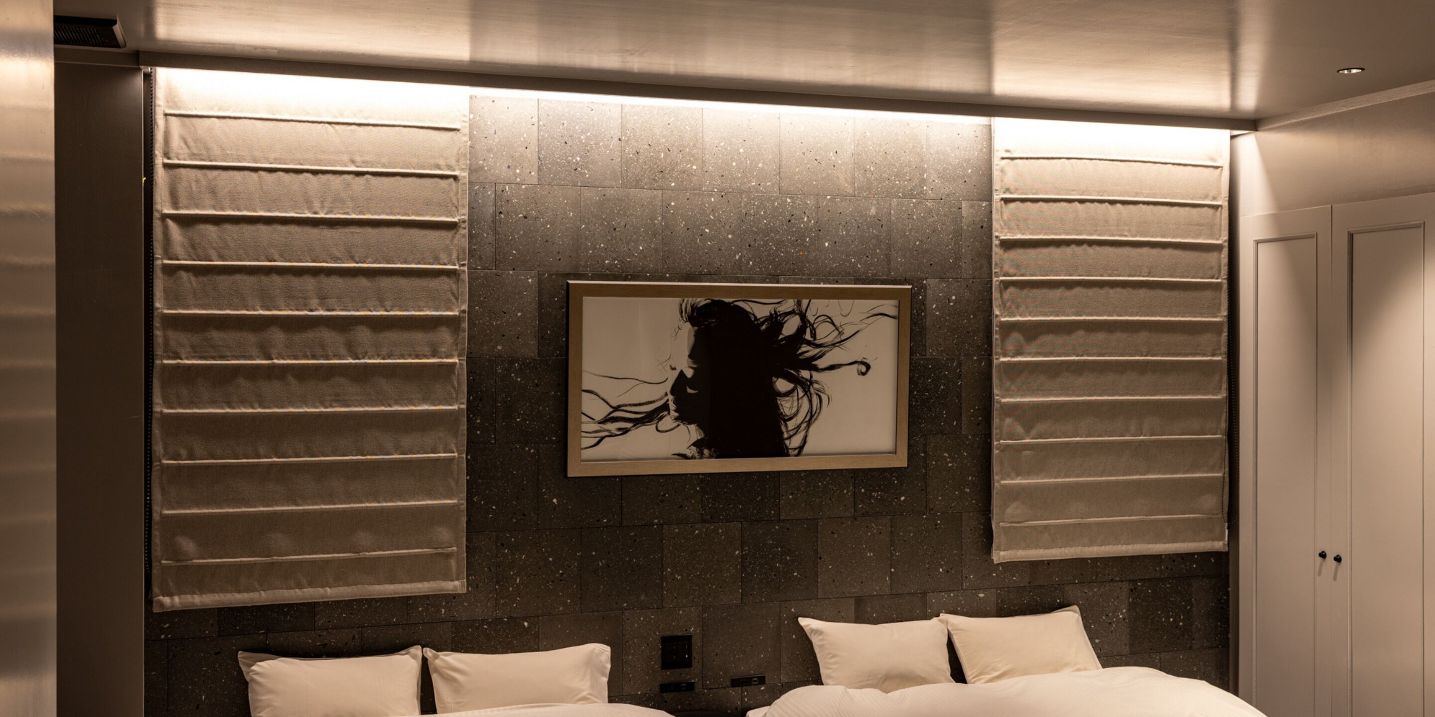 Una camera d'albergo con un letto grande, un'opera d'arte appesa al muro e una porta.