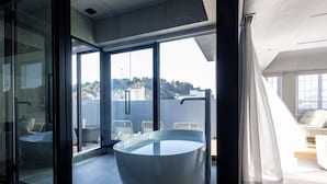A modern bathroom with a glass enclosure, a bathtub, and a view of a cityscape. - asuwagawaritoa-to asunowa (Fukui)