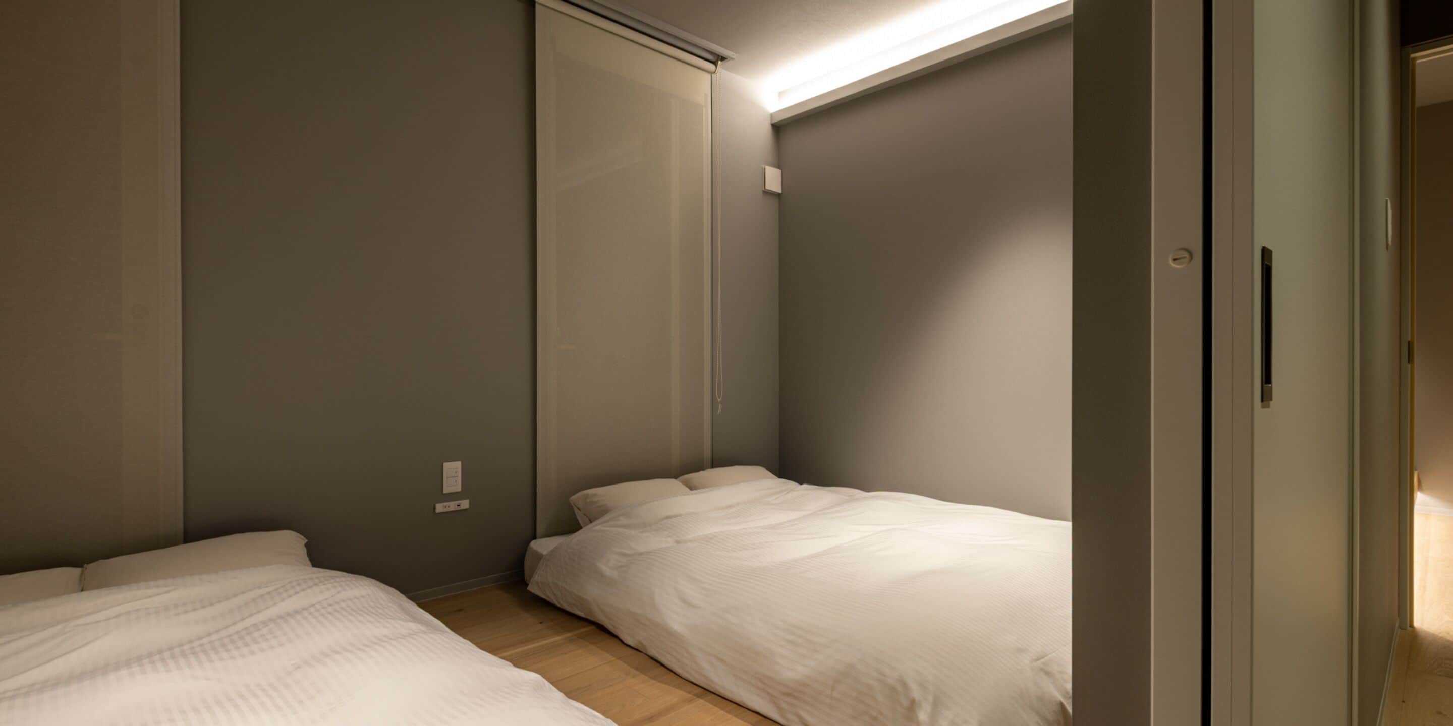 Un dormitorio con dos camas, un armario y una puerta que da a otra habitación.