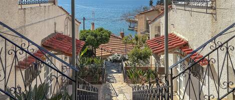 A staircase leading to a terrace with a view of the sea and mountains.